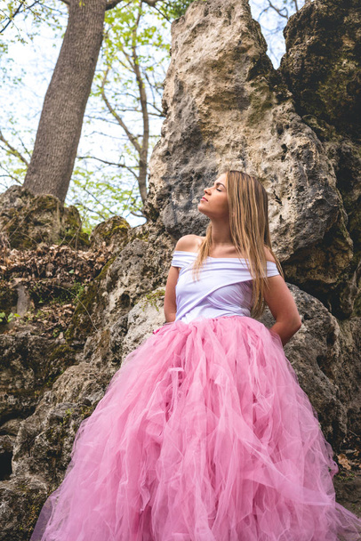 放棄された場所で悲しくなっているピンクのチュールスカートを着た美しい金髪の若い女性 - 写真・画像
