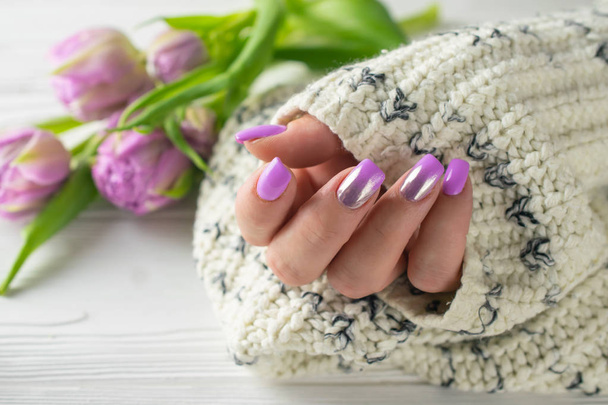 Las manos de la mujer arreglada con esmalte de uñas púrpura, manicura, cuidado de las manos
 - Foto, Imagen