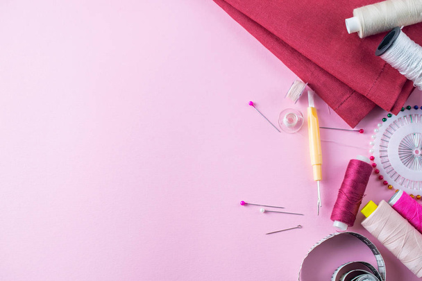 ピンクの背景にカラフルな縫製糸、オーバーヘッドフラットレイ - 写真・画像