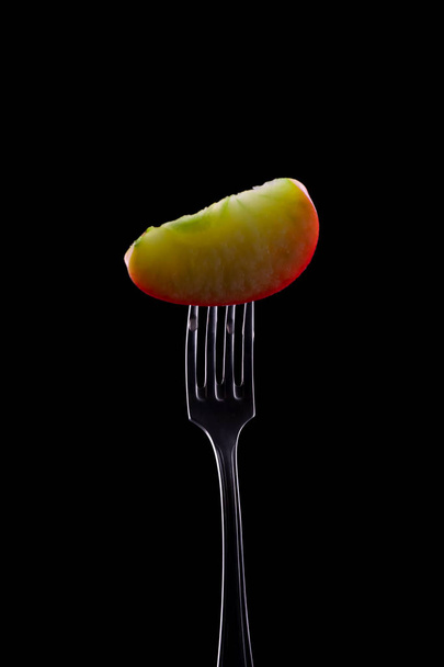 Manzana en tenedor con fondo negro
 - Foto, imagen