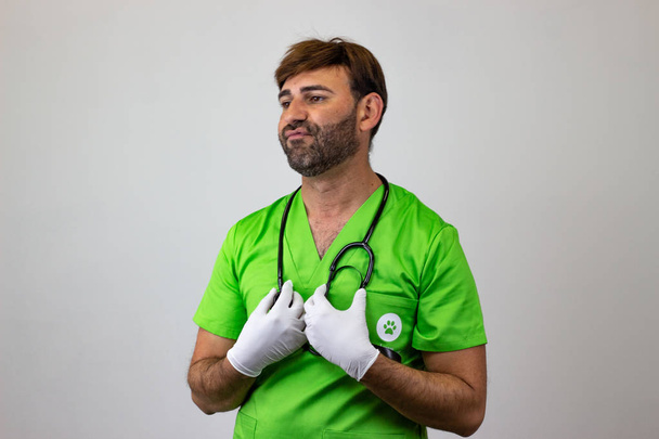 Πορτρέτο του αρσενικού κτηνιατρικού γιατρού με πράσινη στολή με καφέ h - Φωτογραφία, εικόνα
