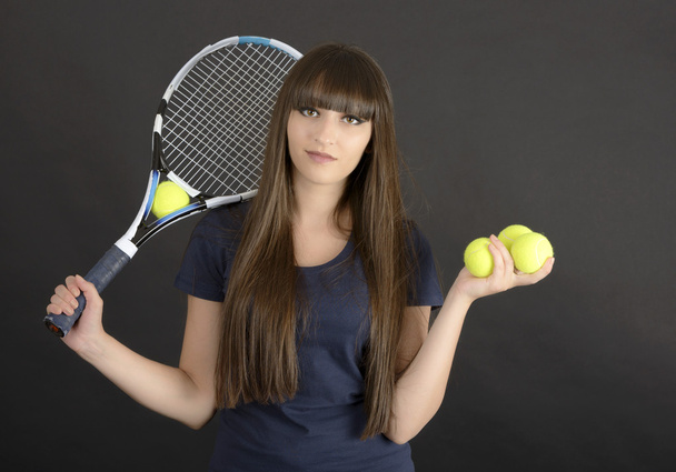 Siyah arka planda raketi ve topu olan bayan tenisçi - Fotoğraf, Görsel