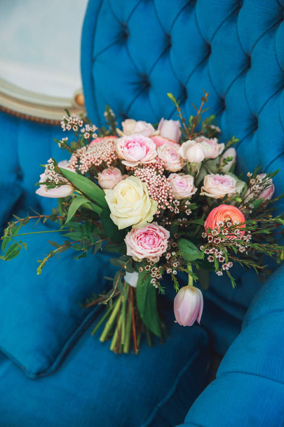 wedding bouquet with pink tulips, peonies, and greens on a blue sofa. - 写真・画像
