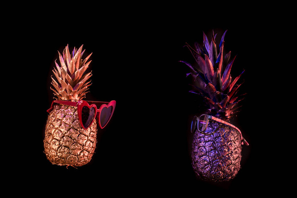 creative pineapples with glasses on a black background - Foto, Bild