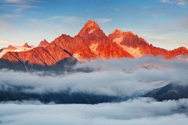 Schilderachtig uitzicht op de bergen in de buurt van hemel en wolken - Foto, afbeelding