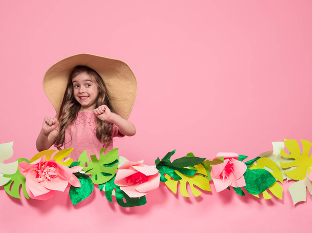 Pienen tytön muotokuva kesähatussa vaaleanpunaisella taustalla
 - Valokuva, kuva