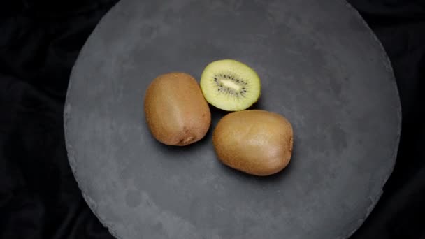 Rotating kiwi fruit on black background. Top view. - Footage, Video