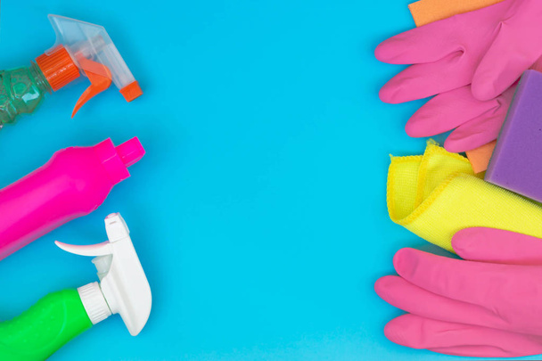 Colorful cleaning set for different surfaces in kitchen, bathroom and other rooms. Empty place for text or logo on blue background. Cleaning service concept. Early spring regular clean up. Top view. - Photo, Image