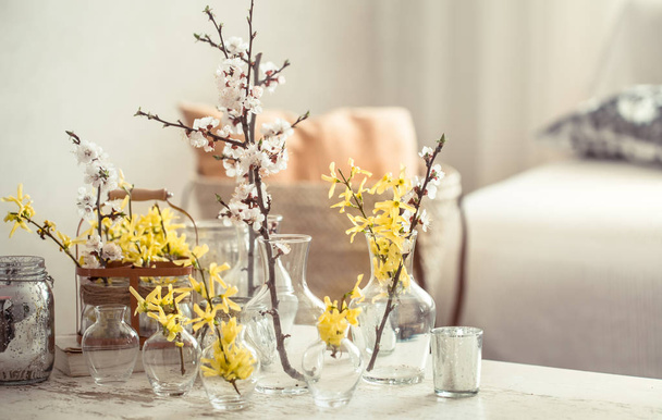 Натюрморт с вазами с весенними цветами в гостиной
 - Фото, изображение