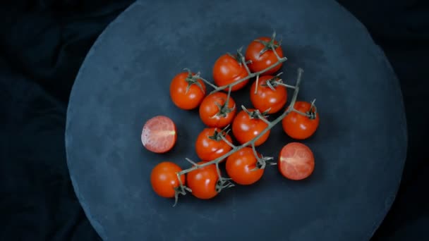 Rotující rajčata červené třešně na černém pozadí. Pohled shora. - Záběry, video
