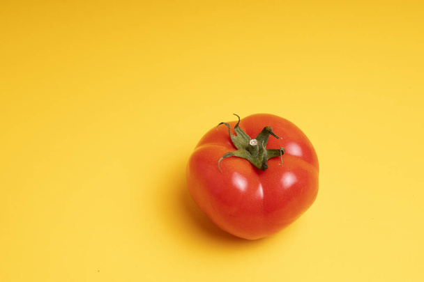 red tomato on a yellow background - Φωτογραφία, εικόνα
