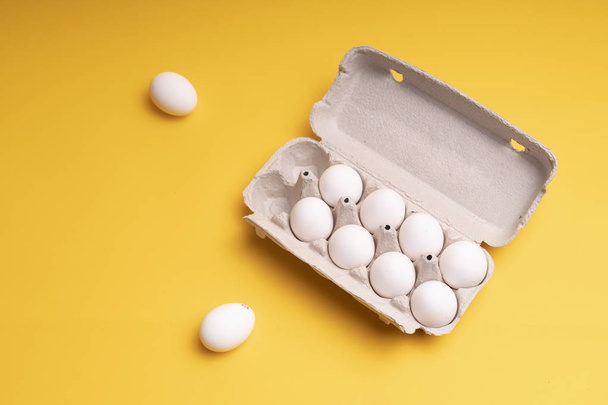 Huevos de pollo en una bandeja sobre un fondo amarillo - Foto, imagen