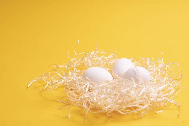 eggs in a nest on a yellow background - Φωτογραφία, εικόνα