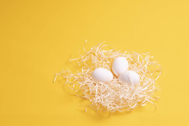 eggs in a nest on a yellow background - Φωτογραφία, εικόνα