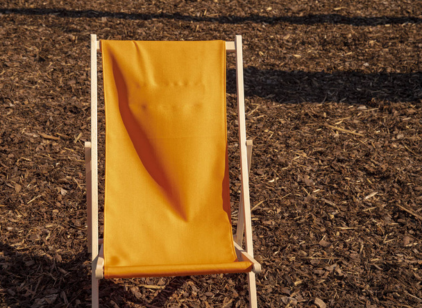 Pusty leżak z pomarańczową pokrywą tkaniny czekając na lato - Zdjęcie, obraz