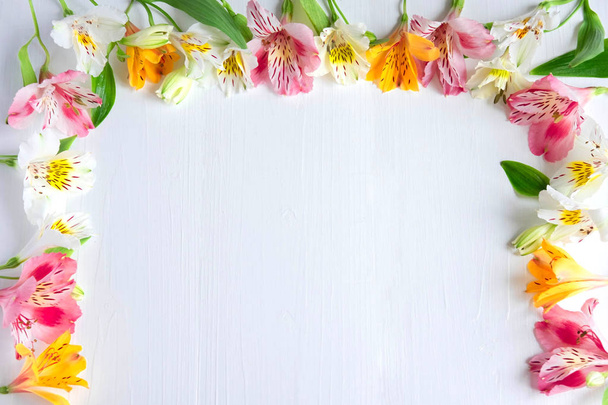 Frame for greeting card with flowers. Banner with natural astromeria flowers on a wooden background. Frame for text with flowers of astromeria. Flat lay, top view. - Fotoğraf, Görsel