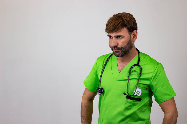 Portrait of male veterinary doctor in green uniform with brown h - Photo, image