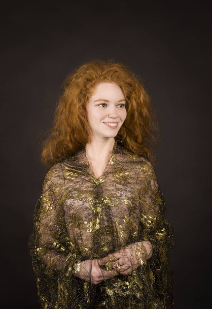 Emotional, red-haired girl in a brocade blouse posing. - Fotó, kép