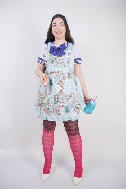 Urocza brunetka gotowanie dziewczyna w szkole anime mundur i kuchnia fartuch na białym tle w Studio - Zdjęcie, obraz