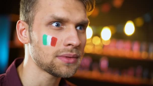 Alegre abanico italiano con bandera pintada en la mejilla gritando, gol de anotación del equipo
 - Imágenes, Vídeo