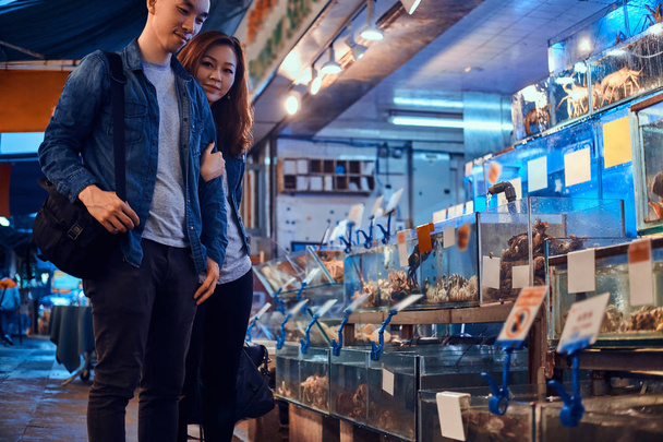 Giovane coppia asiatica in cerca di qualcosa di speciale al mercato tradizionale chainese
 - Foto, immagini