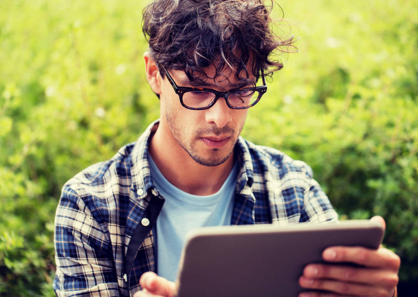 man in glasses with tablet pc computer outdoors - Foto, immagini