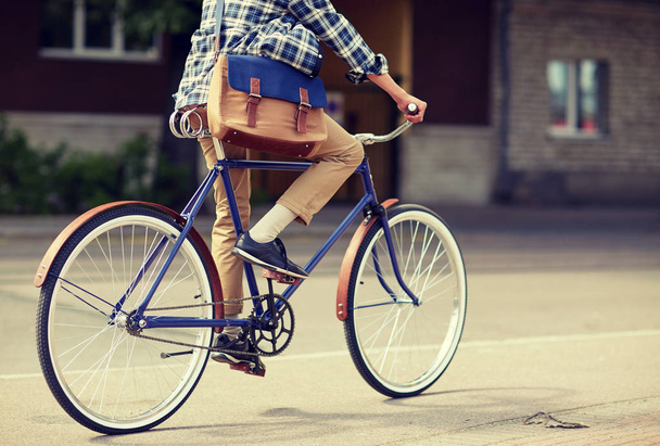 young hipster man with bag riding fixed gear bike - Foto, imagen