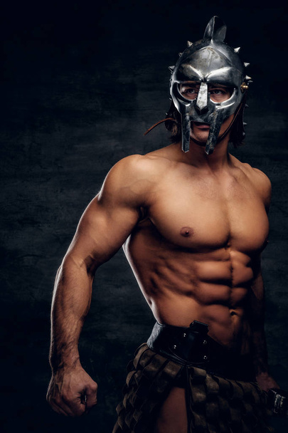 Forte gladiatore a torso nudo in casco sta mostrando i suoi muscoli
 - Foto, immagini