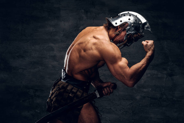 starker hemdloser Gladiator im Helm zeigt seine Muskeln - Foto, Bild