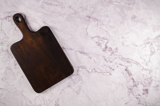 Wooden cutting board on a gray marble background - Fotoğraf, Görsel