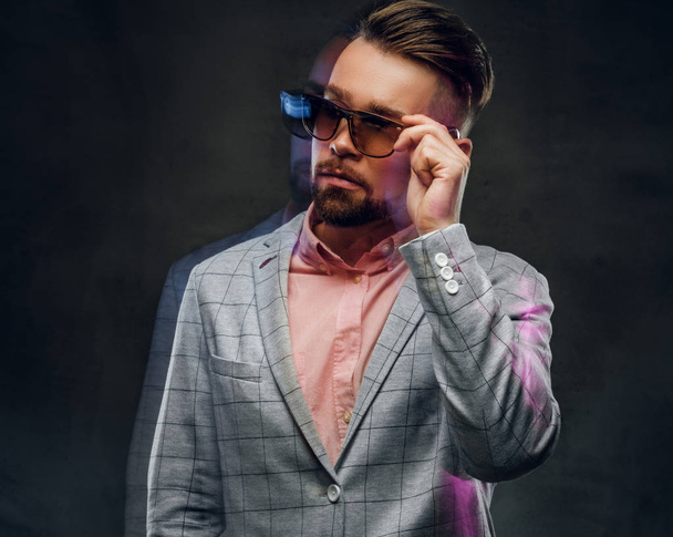 Foto des attraktiven smarten Mannes in karierter Blaze, Sonnenbrille und rosa Hemd. - Foto, Bild