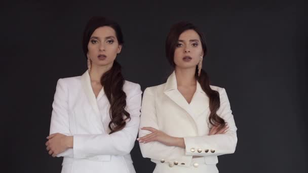 Kobiety Bliźniaczki w białych kombinezony stwarzające podczas konfetti spada - Materiał filmowy, wideo