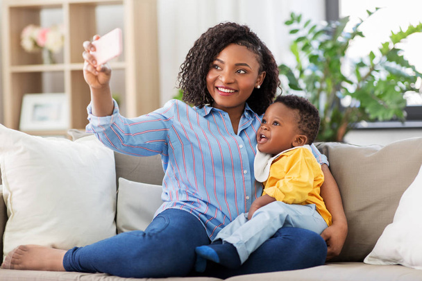 african mother with baby son taking selfie at home - Foto, Bild