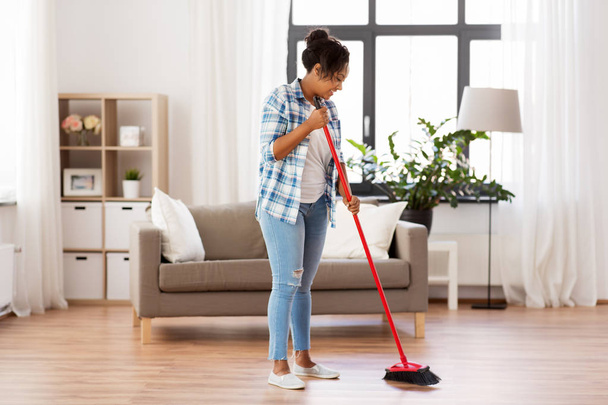 woman with sweeping broom brush cleaning floor - Fotografie, Obrázek