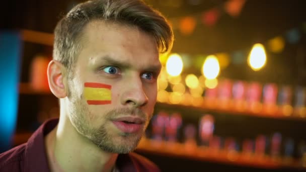 Felice tifoso di calcio spagnolo con bandiera sulla guancia che grida, squadra che segna gol
 - Filmati, video