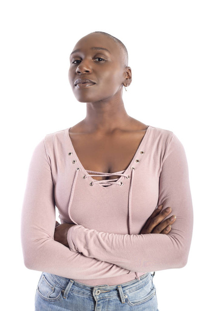 Black african american female model with bald hairstyle wearing a pink shirt on a white background looking confident or arrogant - Foto, afbeelding