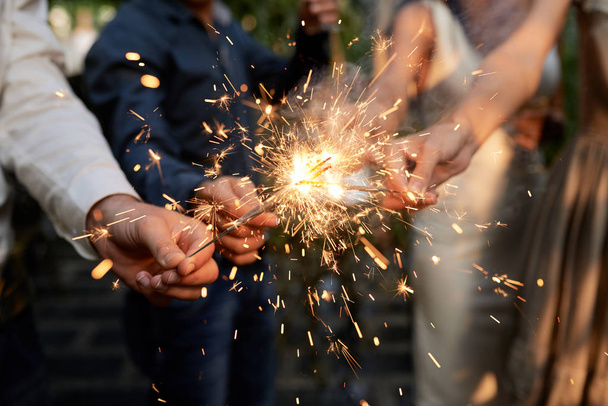 Burning sparklers in hands of party guests - Photo, Image
