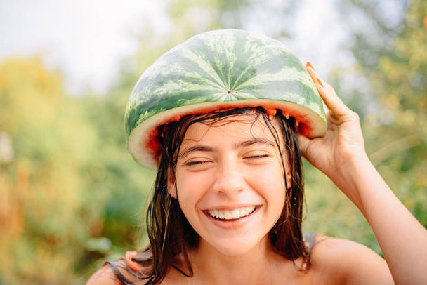 Portrait of pretty funny woman brunette. Autumn discounts on lingerie. Sale of womens panties. Crazy people. Cheerful beautiful girl wearing a watermelon on her head. - Фото, зображення