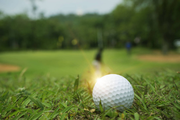 м'яч для гольфу на зеленій траві в красивому полі для гольфу на заході сонця назад
 - Фото, зображення