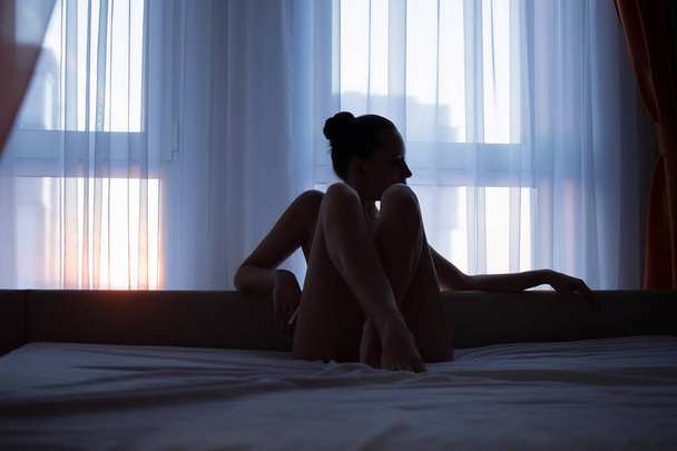 ベッドでポーズ若い官能的な裸の女性 - 写真・画像