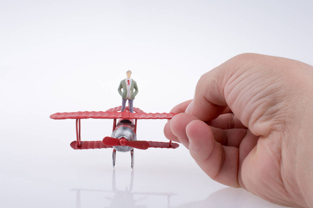 Hand holding plane with a figure on it - Photo, Image