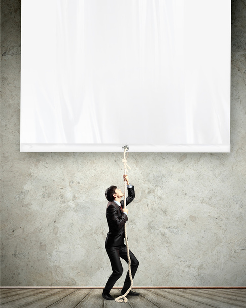 Businessman pulling blank banner - Фото, зображення