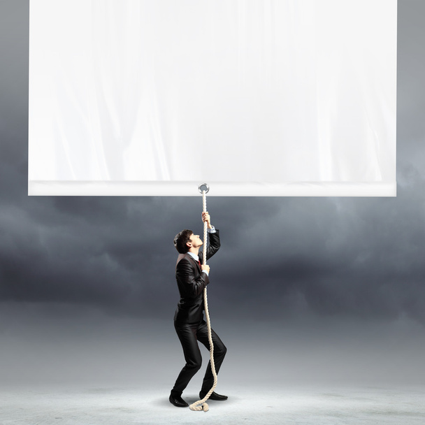 Businessman pulling blank banner - Photo, image