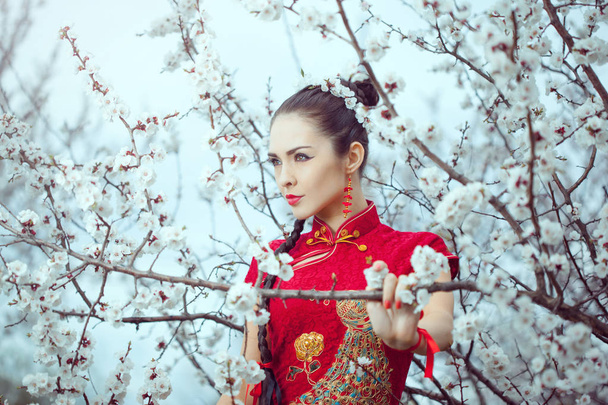 Geisha in red kimono in sakura - Fotoğraf, Görsel