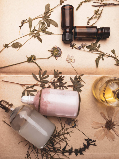 Styled beauty background, web banner. Skin mask, tonicum bottle, dry flowers, leaves. Organic cosmetics, spa concept. top view - Foto, Bild