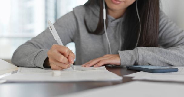 Γυναίκα μελέτη σε χαρτί σημείωμα με κινητό τηλέφωνο στο σπίτι - Φωτογραφία, εικόνα