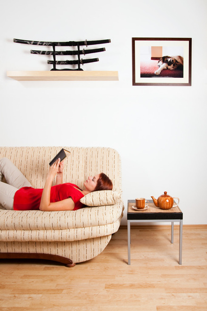Woman lying and reading a book - Фото, изображение