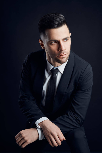 Handsome confident man in black suit on dark background. Man beauty                               - Fotó, kép