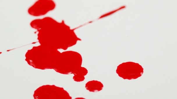 közeli piros színű csepegés a fehér háttér - Felvétel, videó