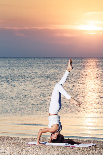 giovane ragazza che fa yoga all'alba sulla spiaggia
. - Foto, immagini